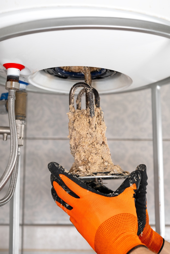 Plumber inspecting a water heater for signs it needs replacement in Chillicothe, OH