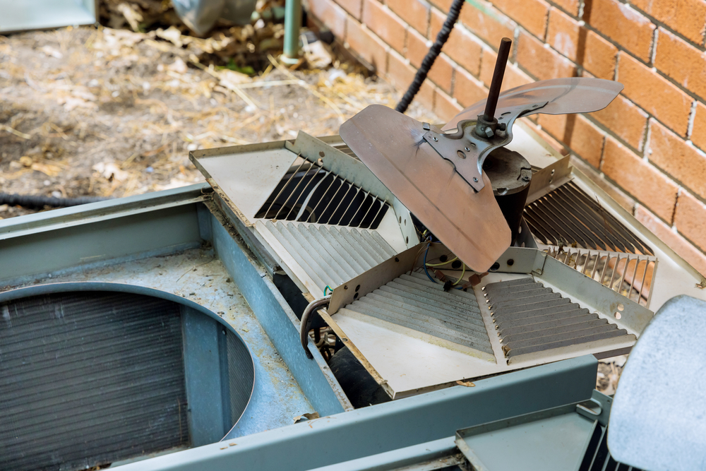 HVAC technician performing air conditioner repair on a residential cooling system