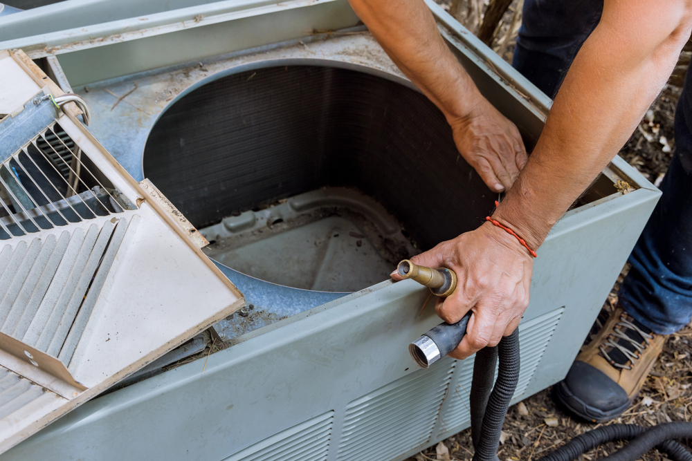 HVAC technician performing a professional air conditioner checkup on a residential AC system
